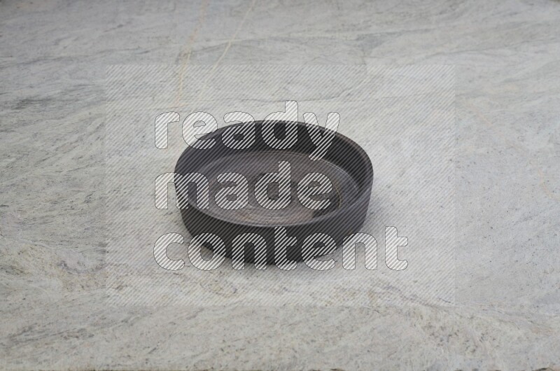 A black pottery oven bowl on grey marble background