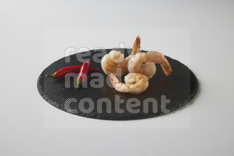 three grilled shrimp  on a black slate direct  on a white back ground
