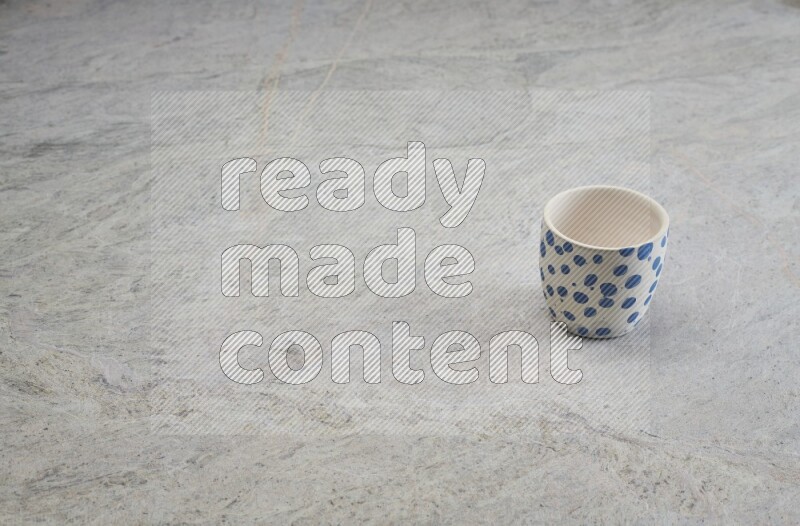 A multicolored pottery Cup on grey marble background