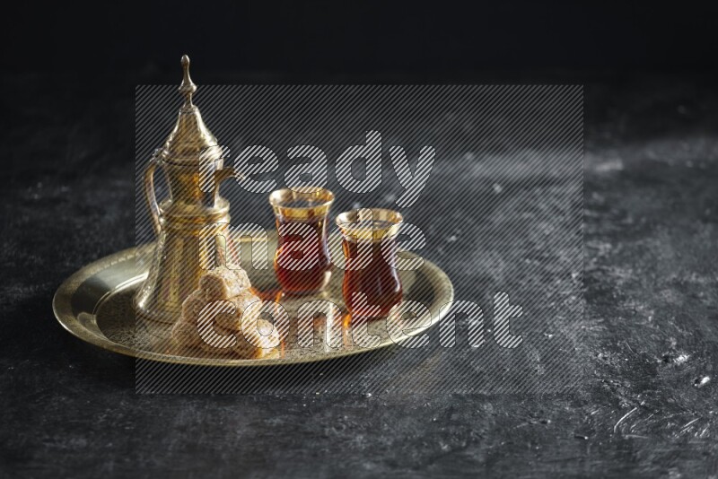 Golash with a drink on a metal tray in a dark setup