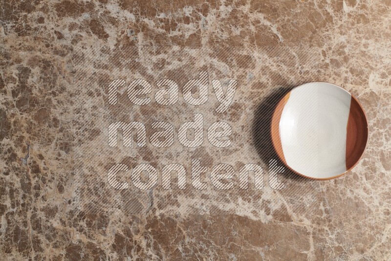 A decorative pottery plate on beige marble background