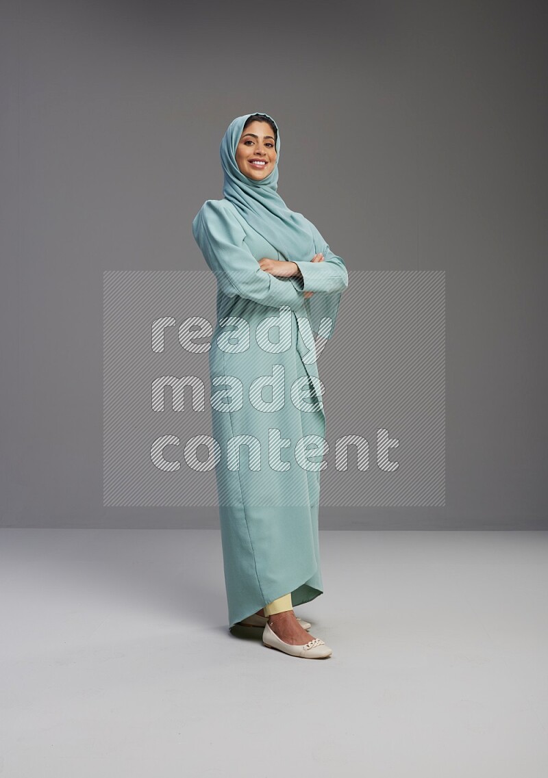 Saudi Woman wearing Abaya standing with crossed arms on Gray background