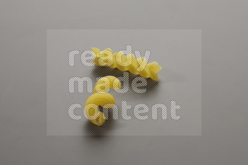 Twist pasta with other types of pasta on grey background