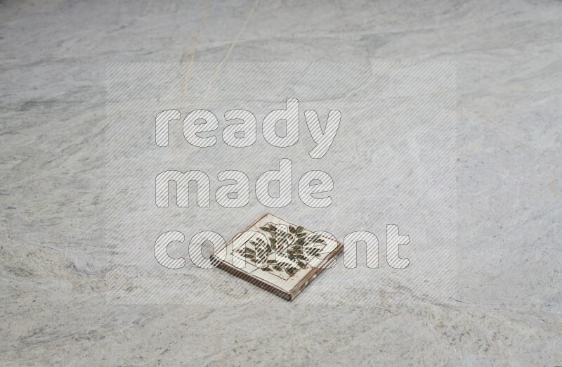 Top view shot of a pottery coaster\ tile on beige marble flooring