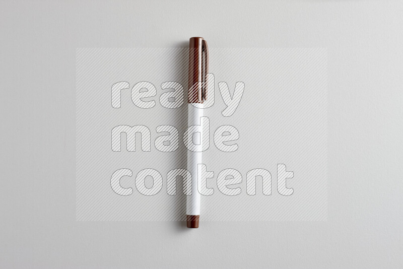 A close-up showing a single coloring pen with a cap on grey background