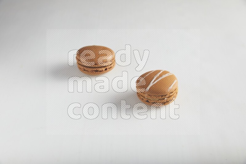 45º Shot of of two assorted Brown Irish Cream, and Brown Coffee macarons  on white background