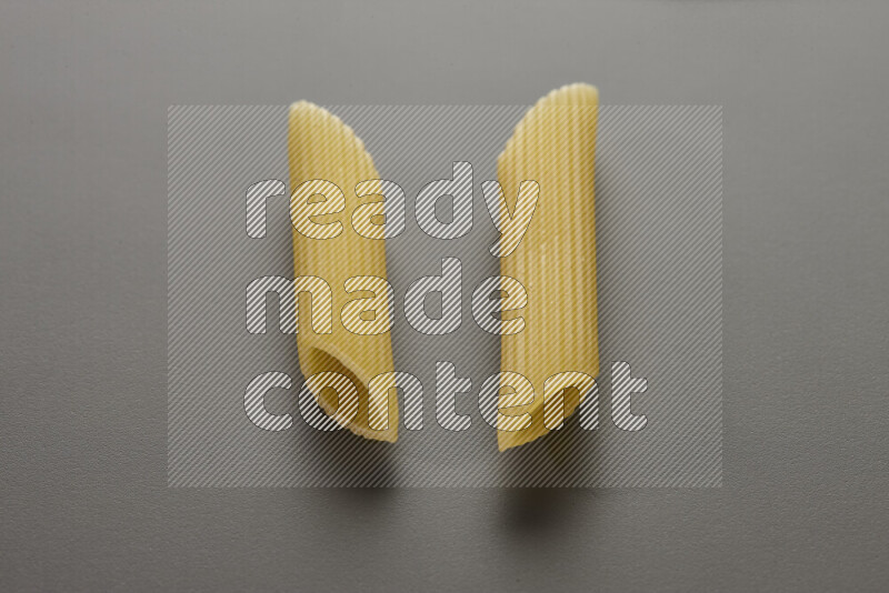 Penne pasta on grey background