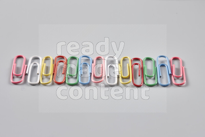 Multicolored paper clips isolated on a grey background