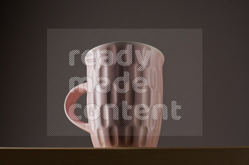 Low angle shot of a pink cup on grey background