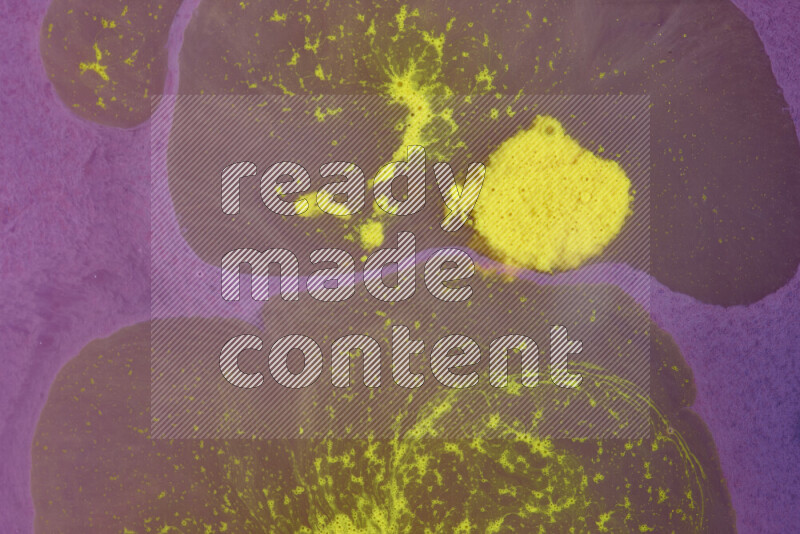 The image depicts a marbling effect with swirling patterns of purple and yellow