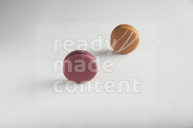 45º Shot of of two assorted Brown Irish Cream, and Red Cherry macarons on white background
