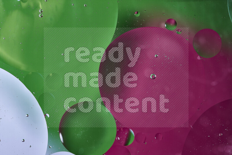 Close-ups of abstract oil bubbles on water surface in shades of green and pink