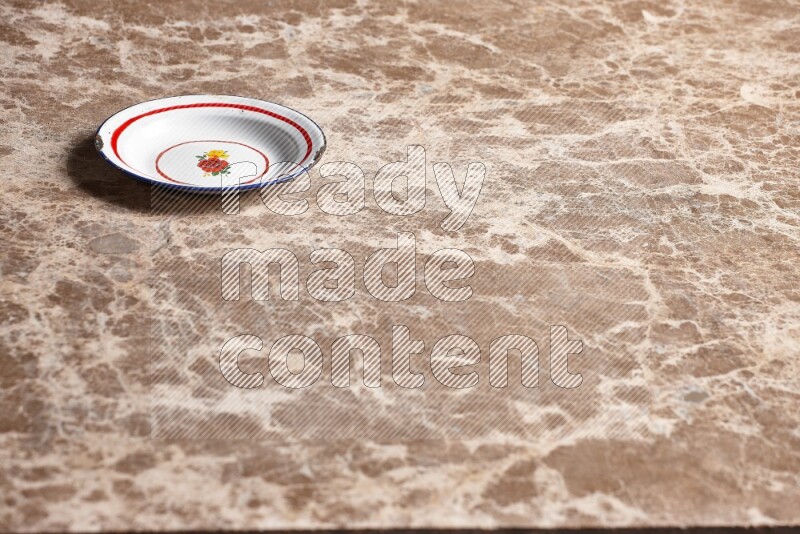 A vintage metal plate on beige marble background