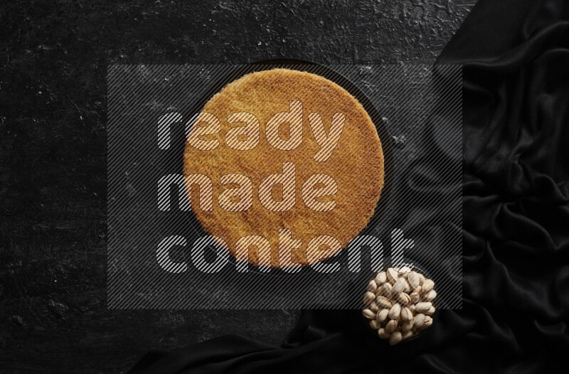 Konafa with nuts and honey in a dark setup