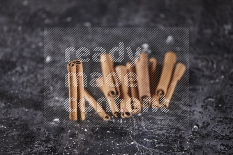Cinnamon sticks on a textured black background