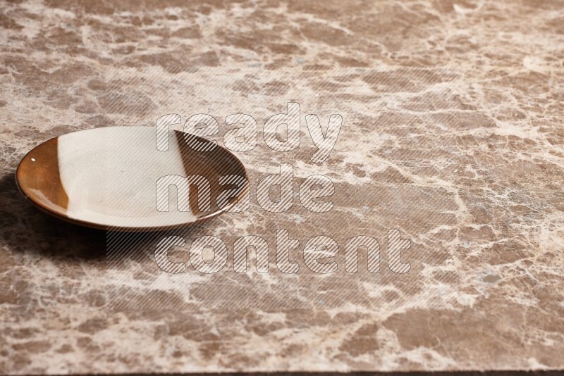 A multicolored pottery plate on beige marble background