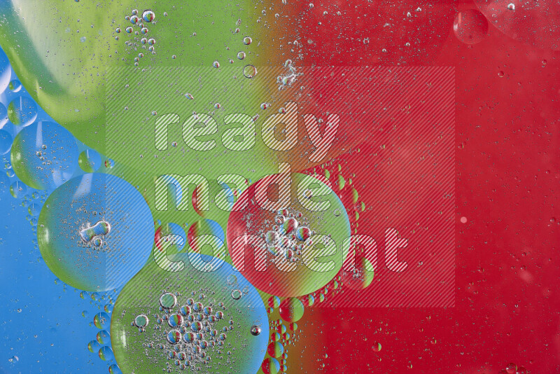 Close-ups of abstract oil bubbles on water surface in shades of red, green and blue