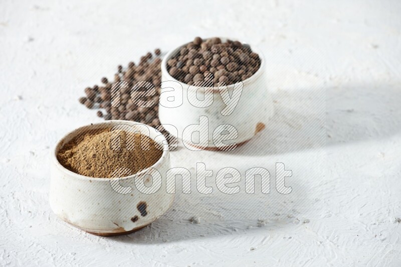 2 beige bowls, one full of powder and the other full of whole balls with balls and powder spreaded on a textured white flooring