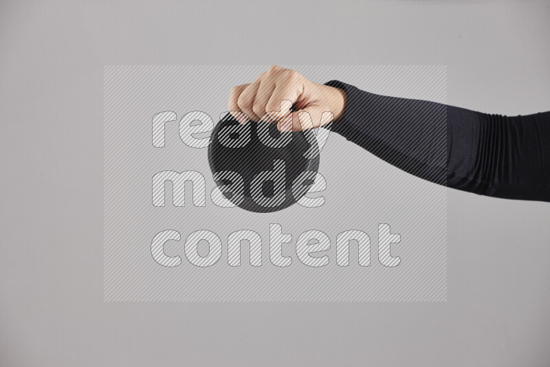 A woman in black abaya holding different pottery essentials in different positions