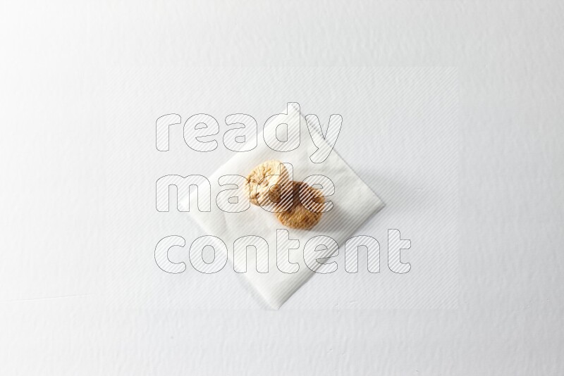 Two dried figs on a piece of paper on a white background in different angles