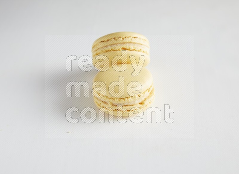 45º Shot of two Yellow Vanilla macarons on white background