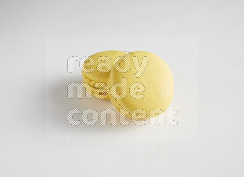45º Shot of two Yellow Lemon macarons on white background