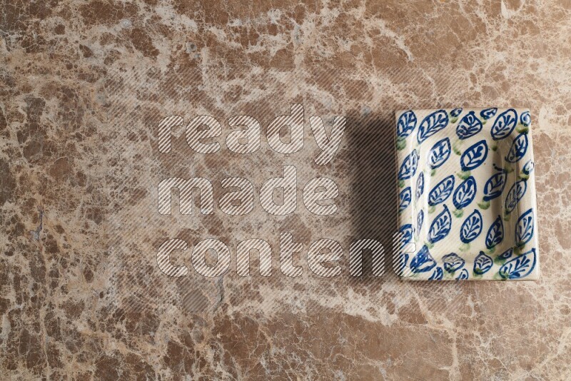 A decorative pottery plate on beige marble background