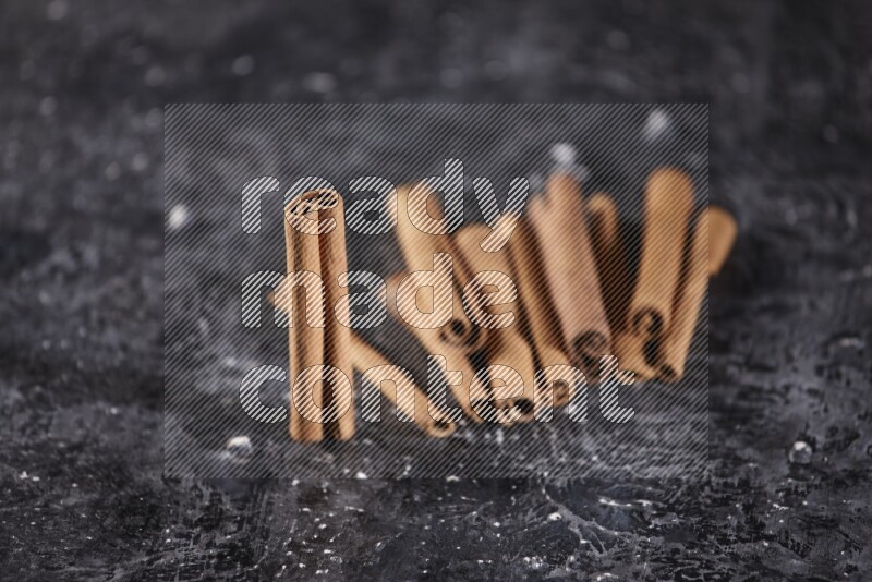 Cinnamon sticks on a textured black background