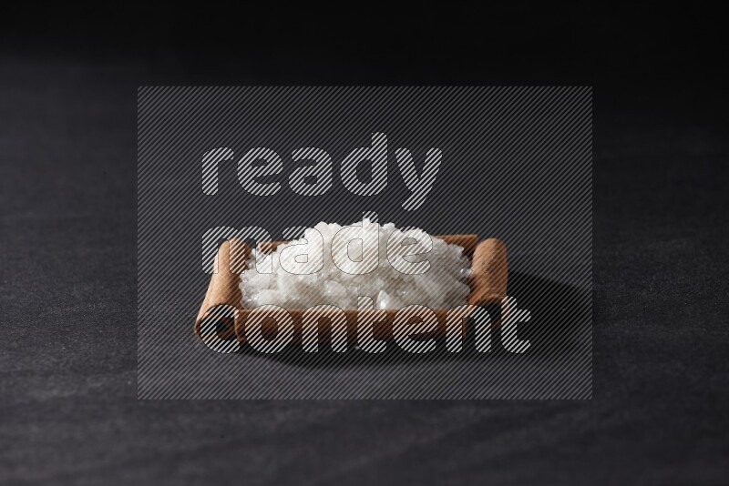 A single square of cinnamon sticks full of salt on black flooring