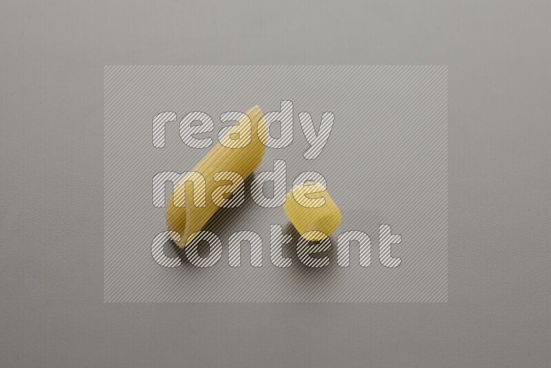 Penne pasta with other types of pasta on grey background