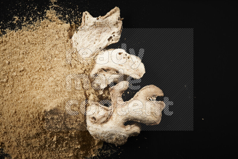 A bunch of ground ginger powder on black background
