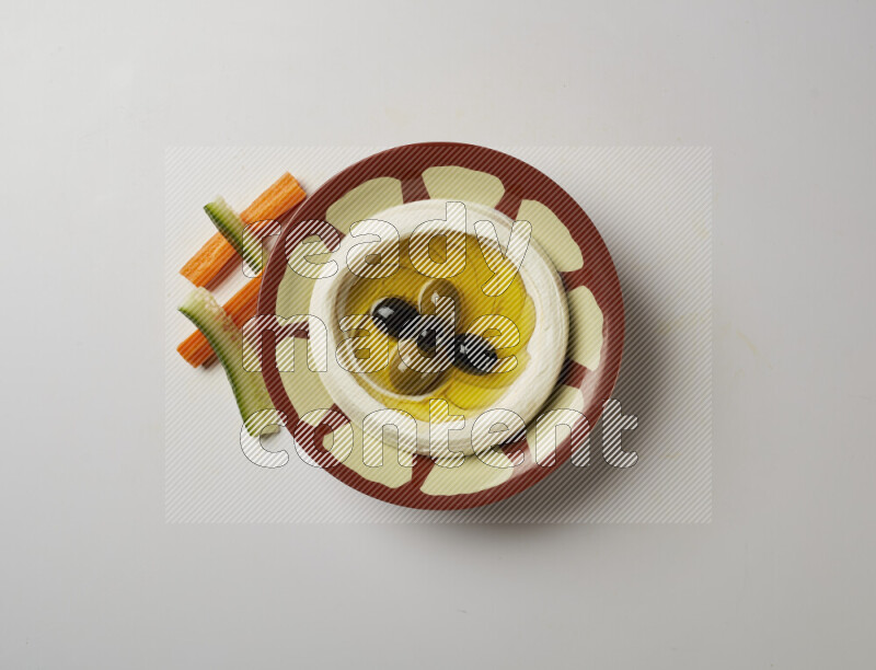 Lebnah garnished with olives in a traditional plate on a white background