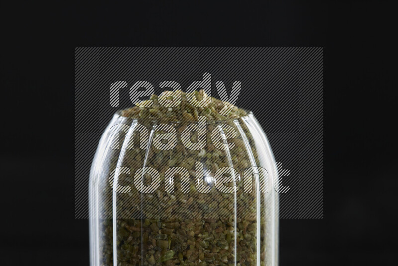 Freekeh in a glass jar on black background