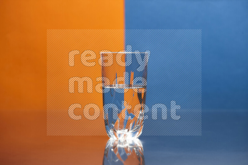 The image features a clear glassware filled with water, set against orange and blue background