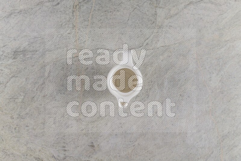 A ceramic milk jug on grey marble background