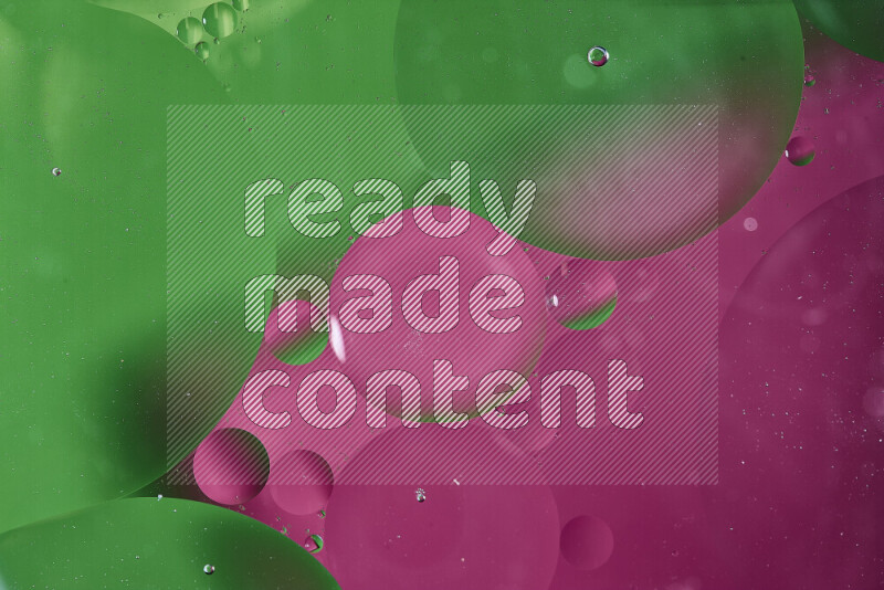 لقطات مقربة لفقاعات من الزيت على سطح الماء باللون الأخضر والوردي