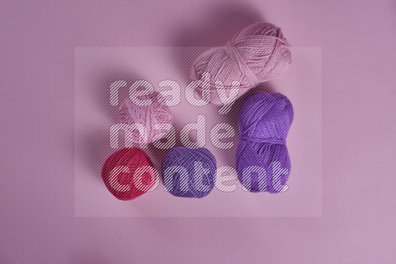 A purple and pink collection of sewing and tailoring tools arranged on a pink background