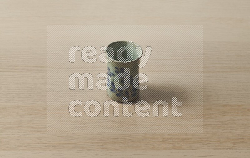 A pottery cup on light wooden background