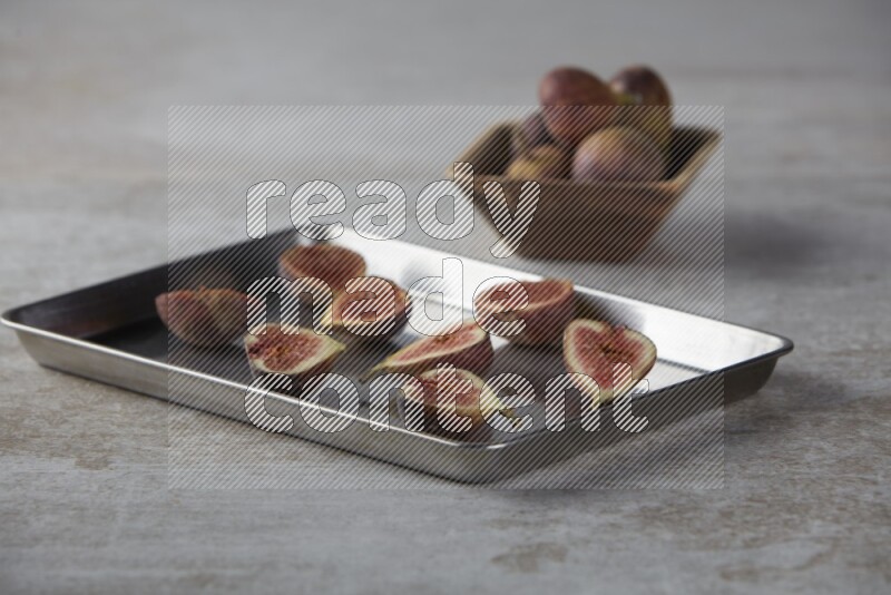 fresh figs on an oven tray on a textured grey background