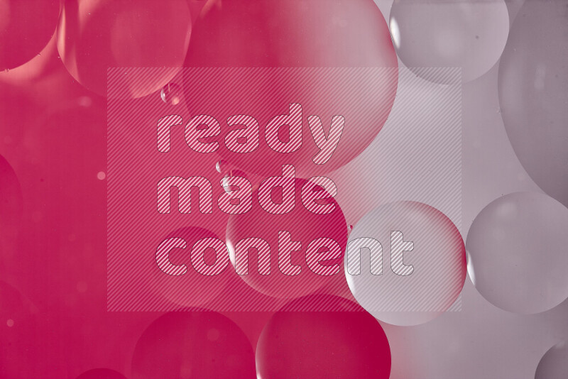 Close-ups of abstract oil bubbles on water surface in shades of white and pink