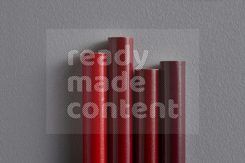 A collection of sharpened colored pencils arranged showcasing a gradient of red hues on grey background