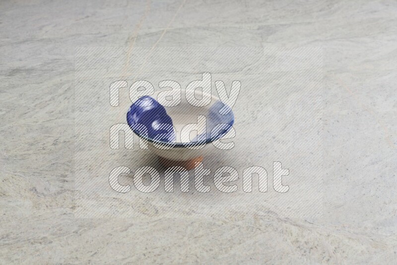 A multicolored pottery bowl on grey marble background