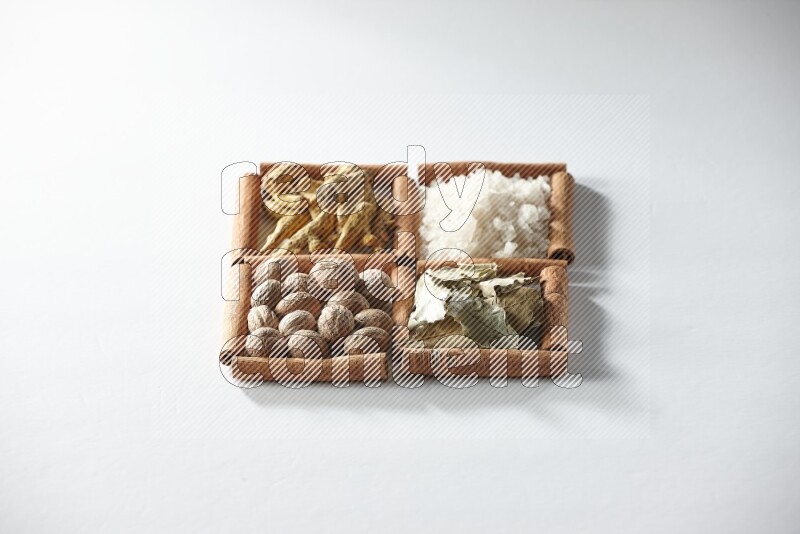 4 squares of cinnamon sticks full of salt, bay laurel, nutmeg, turmeric on white flooring