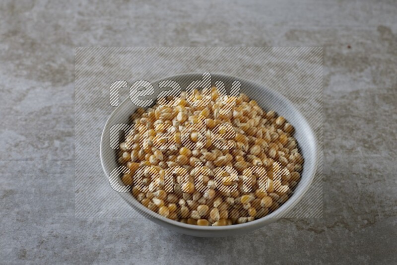 corn kernel in a gray ceramic bowl on a grey textured countertop