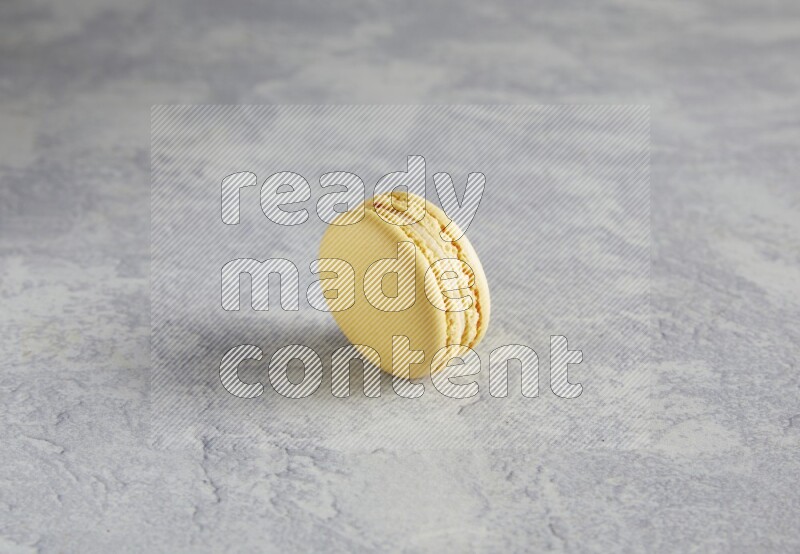 45º Shot of Yellow Vanilla macaron on white  marble background