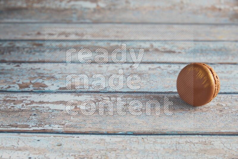 45º Shot of Brown Coffee macaron on light blue wooden background