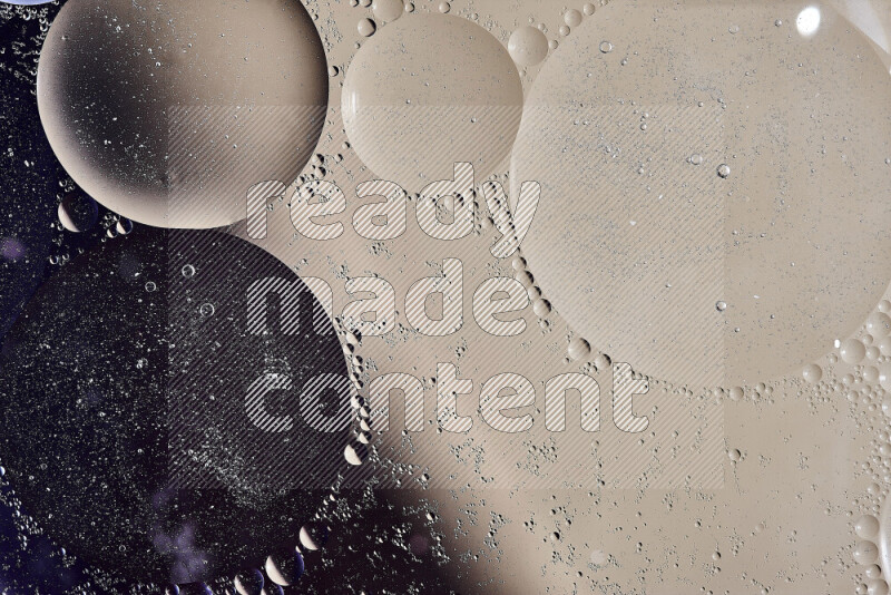Close-ups of abstract oil bubbles on water surface in shades of black and beige