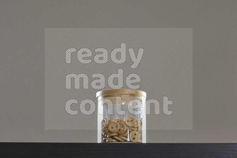 Buttons in a glass jar on black background