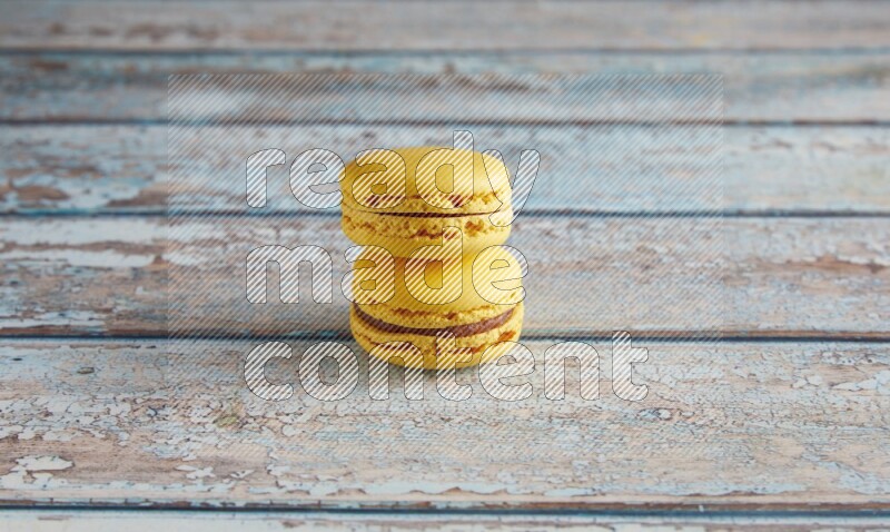45º Shot of two Yellow Lemon macarons on light blue wooden background