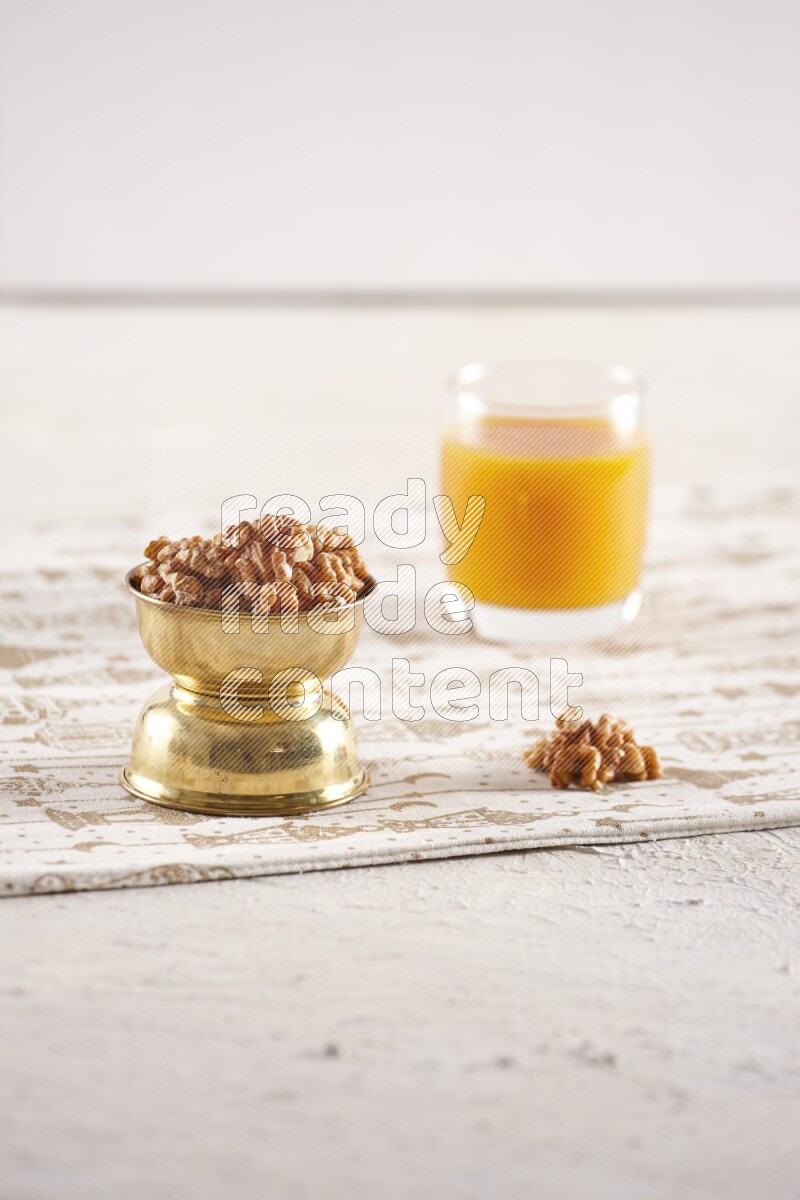 Nuts in a metal bowl with qamar eldin in a light setup